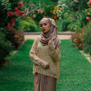 a woman in a hijab standing in a garden